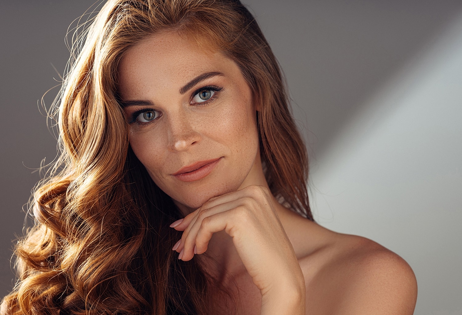 Woman with long, wavy hair and serene expression.