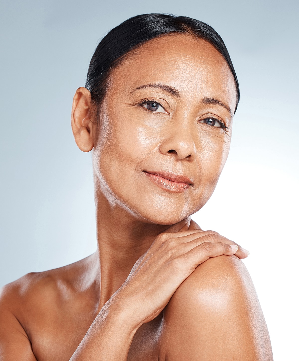 Smiling woman with smooth skin and elegant pose.