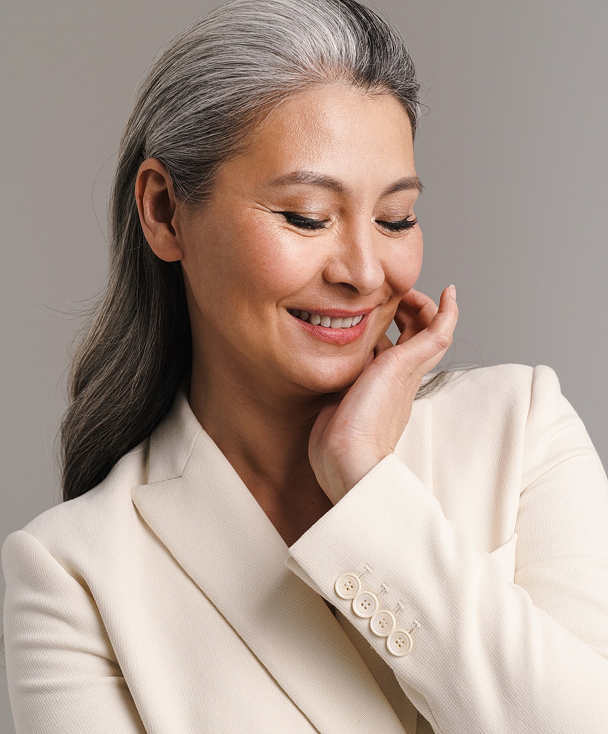 Smiling woman with gray hair in a blazer.