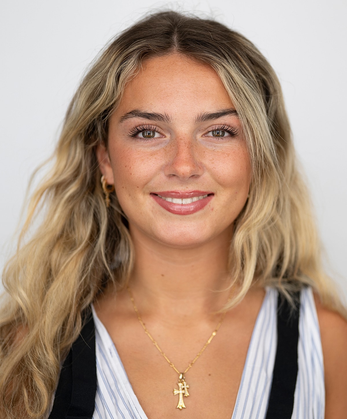 Young woman with wavy hair and necklace.