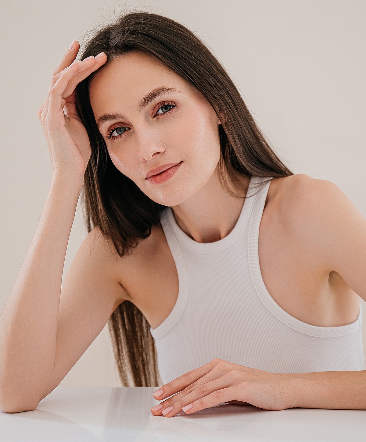 Woman with long hair resting her hand on head