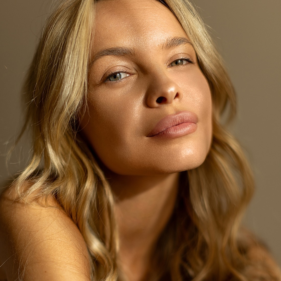 Close-up of a woman with glowing skin.