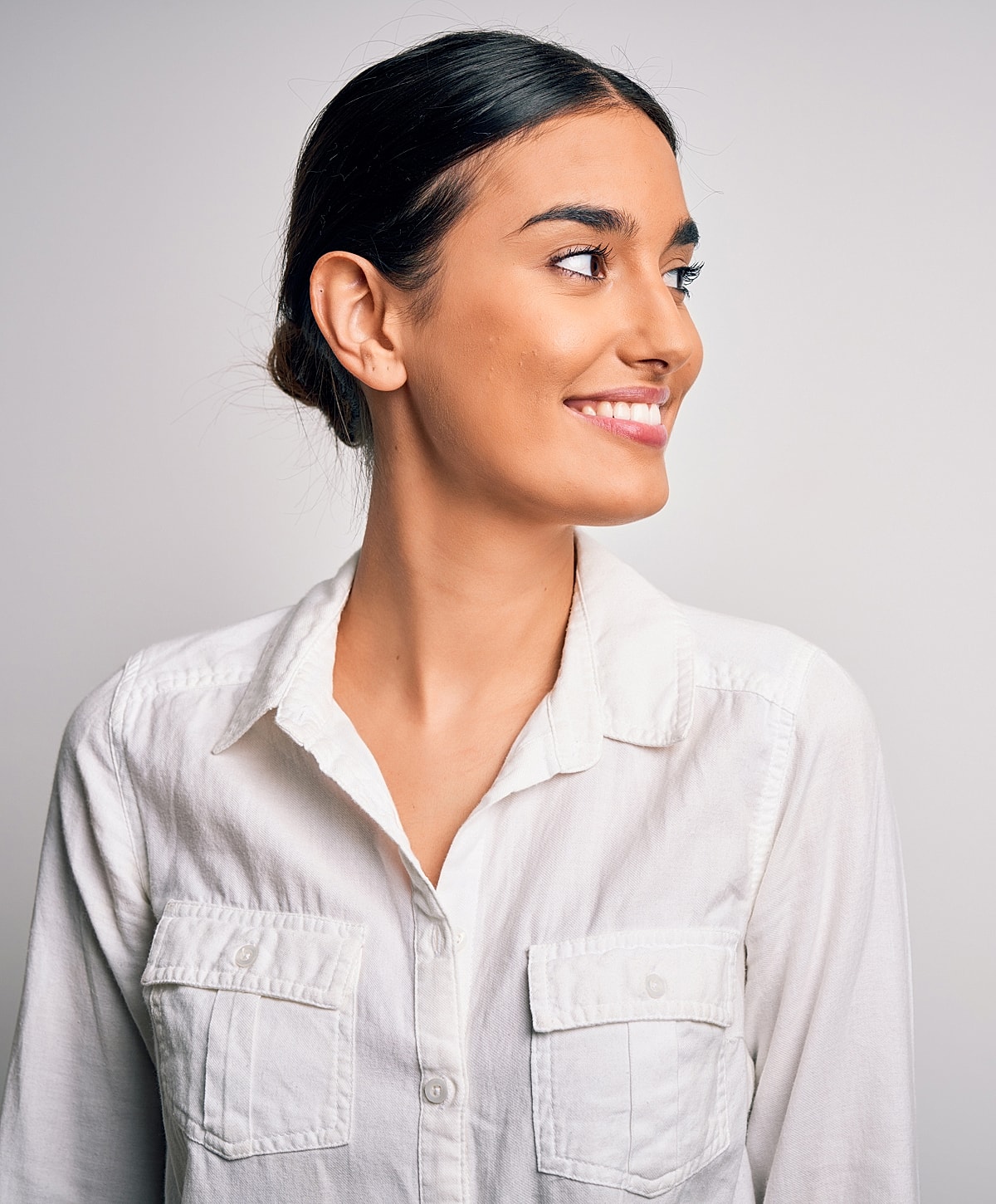 Smiling woman in white shirt, profile view.
