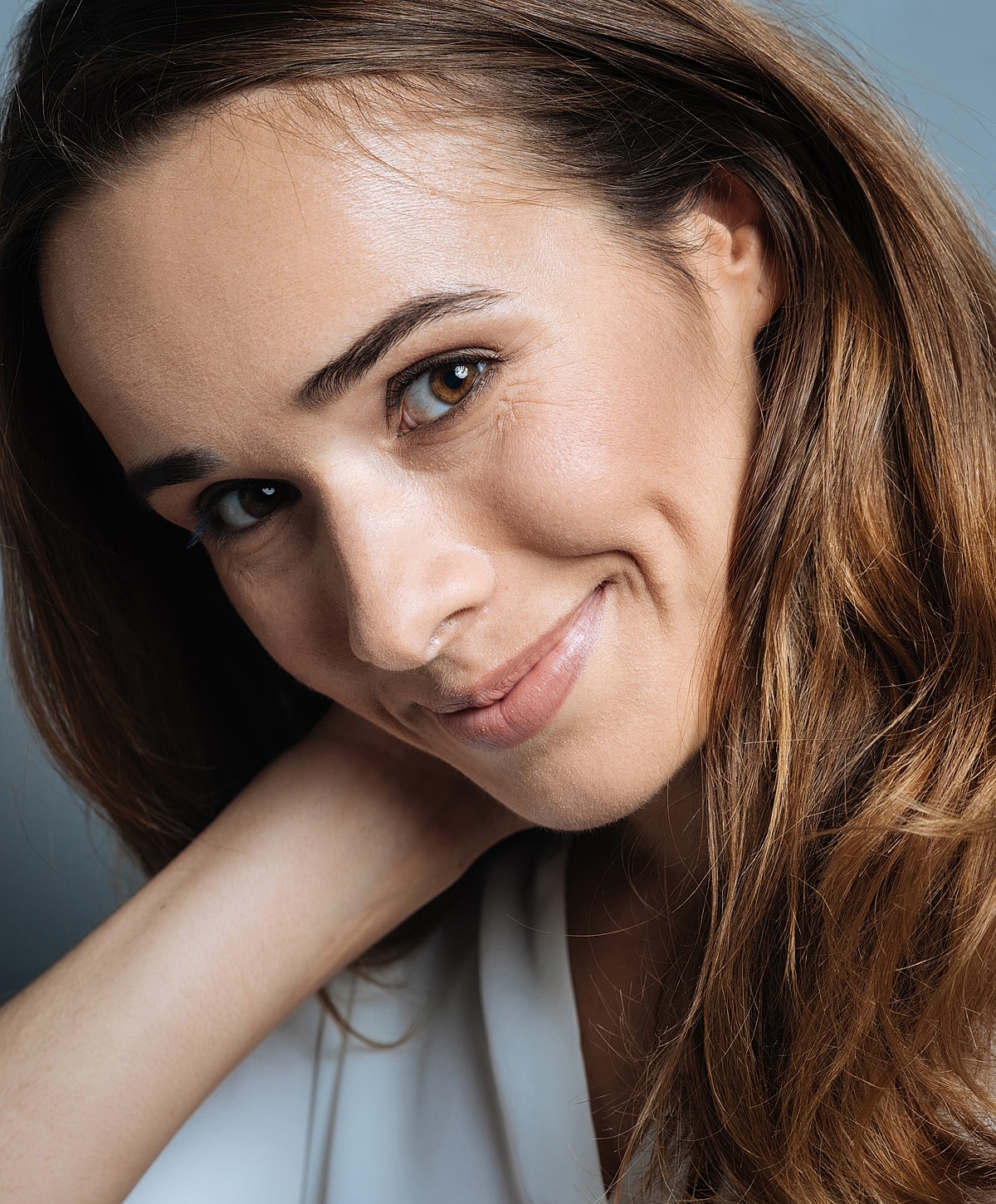 Smiling woman with long, wavy hair.