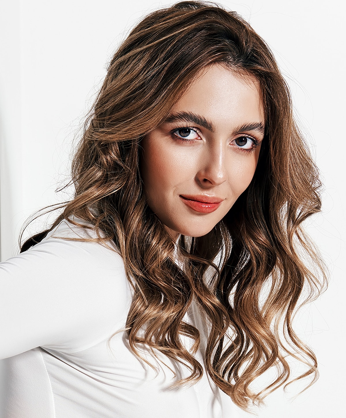 Young woman with wavy hair and natural makeup.