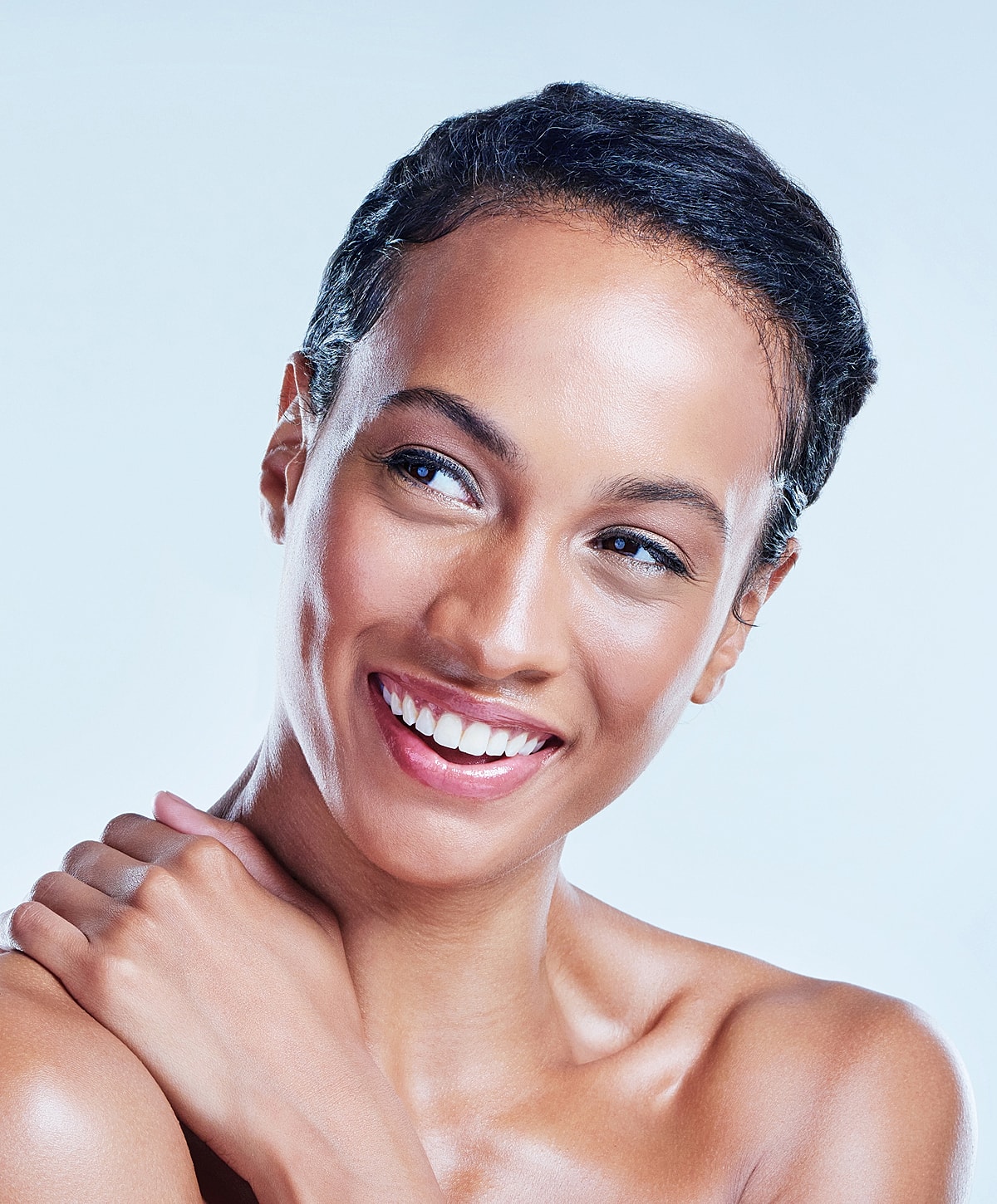 Smiling woman with short hair and flawless skin.