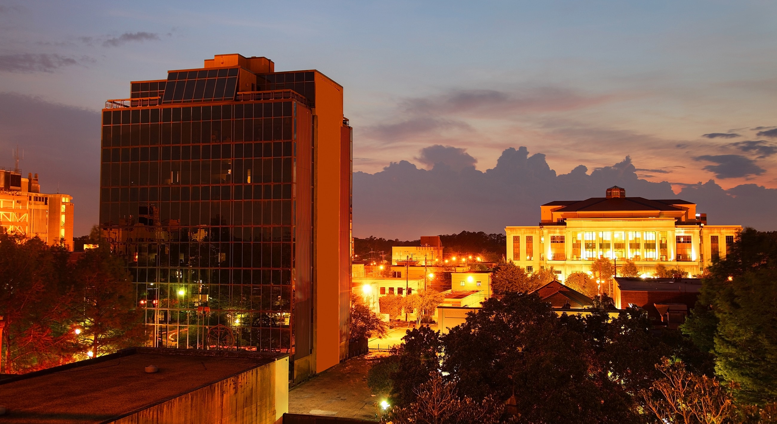 City skyline at dusk with illuminated buildings.