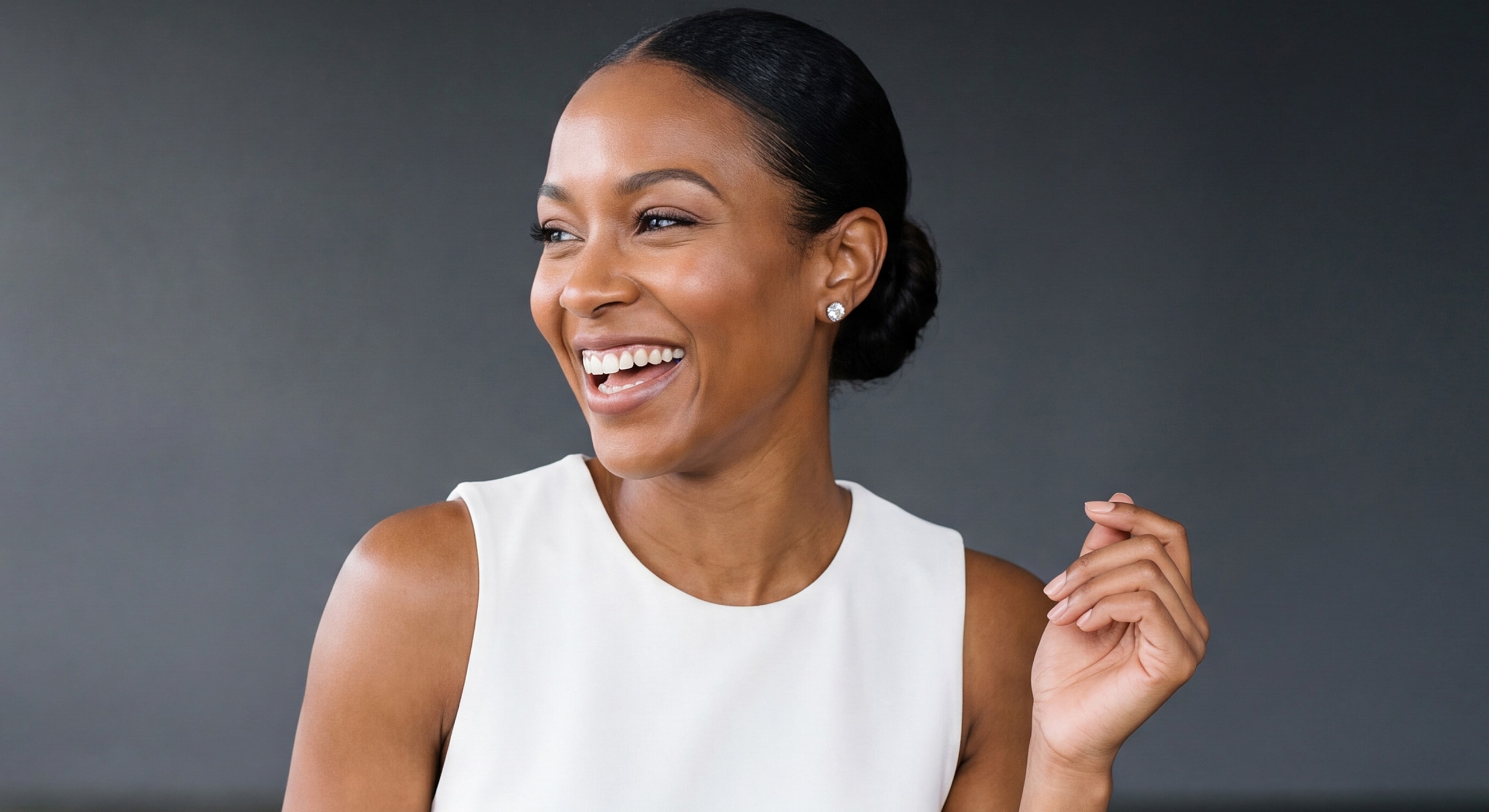 Smiling woman with elegant hairstyle and outfit.