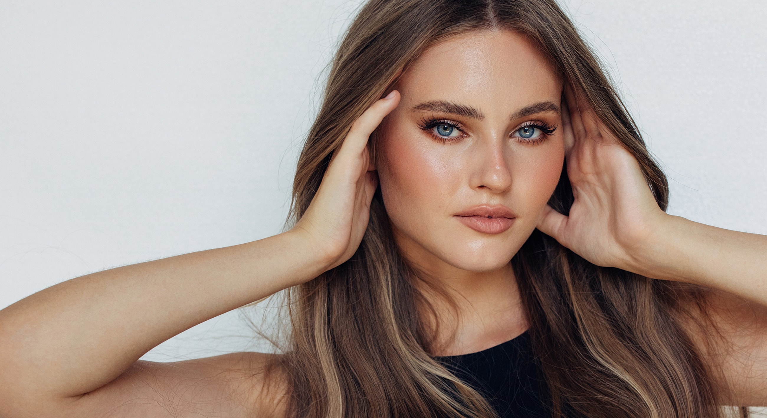 Woman with long hair and natural makeup.