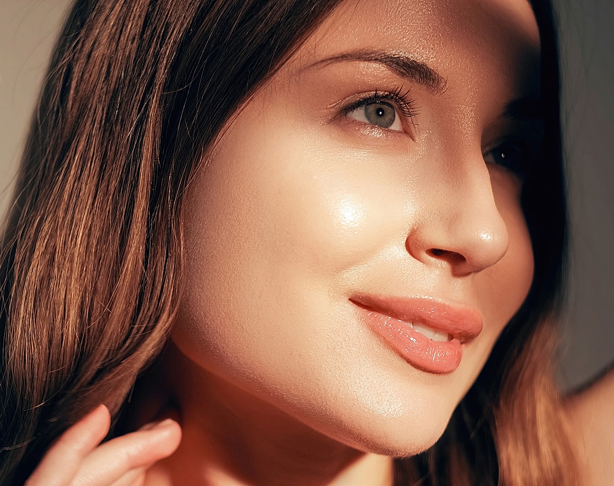 Close-up of a woman with glowing skin.