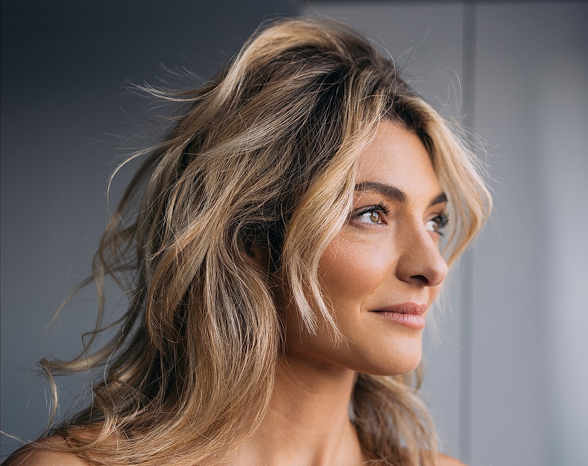 Woman with long, wavy hair facing sideways.